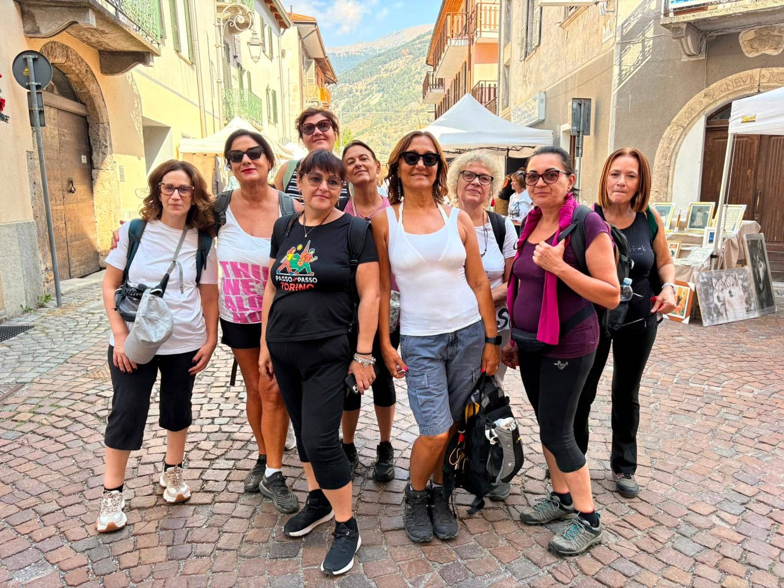 Un gruppo di amiche in gita in un borgo di montagna con le maglie Passo Dopo Passo Torino