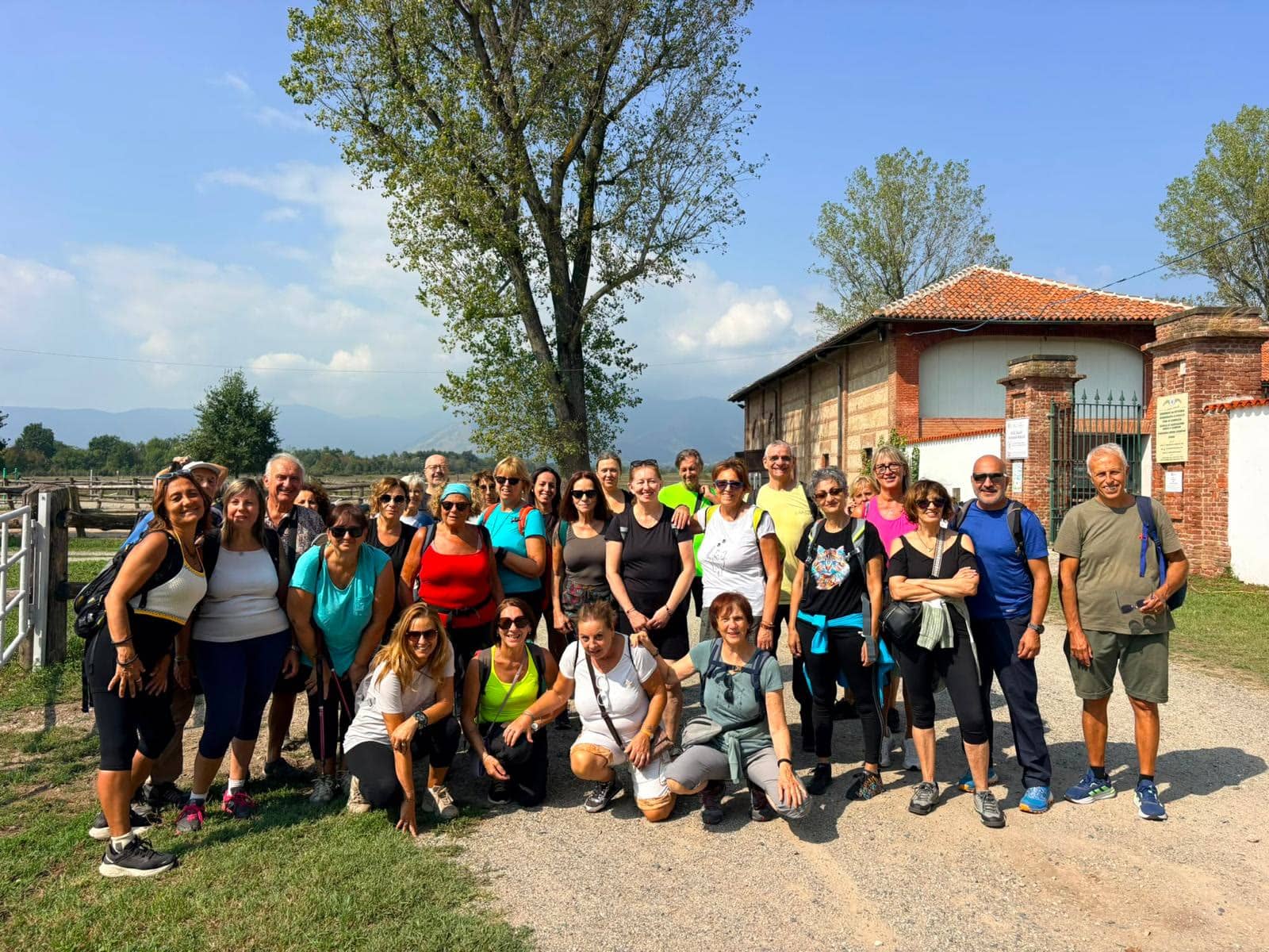 Foto di gruppo durante una gita in cascina, con le montagne sullo sfondo